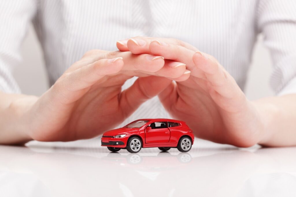 Carros mais seguros do mundo - Na imagem uma pessoa protege um carro miniatura com suas mãos