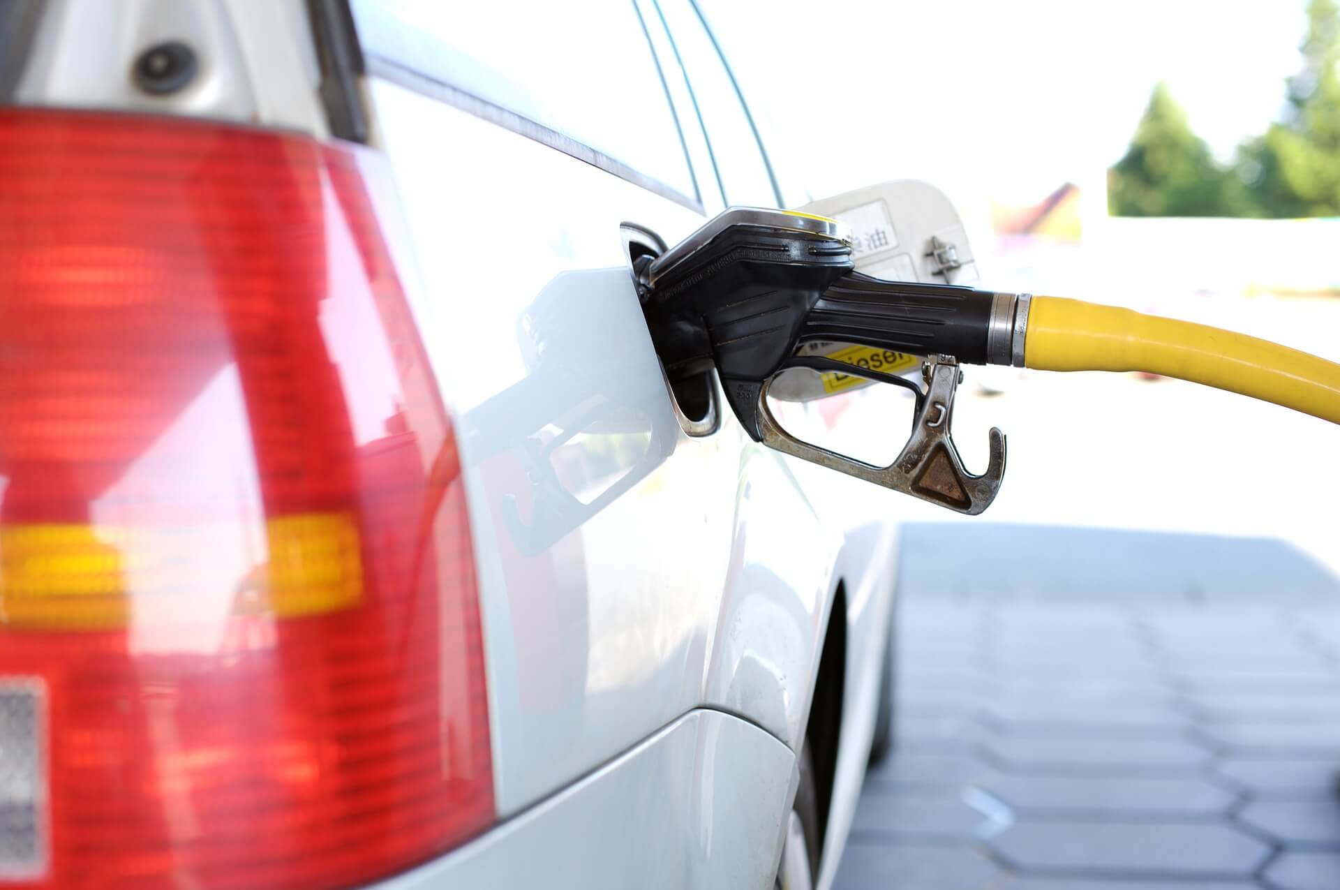 Álcool ou Gasolina: qual vale mais a pena? Na imagem um carro parado em um posto de combustivel sendo abastecido.
