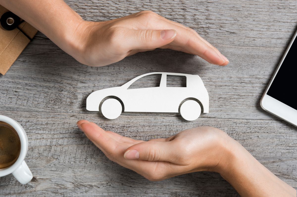 Qual o valor de seguro dos carros mais vendidos em 2023 - Na imagem uma pessoa protege com suas mãos uma moldura de carro. 