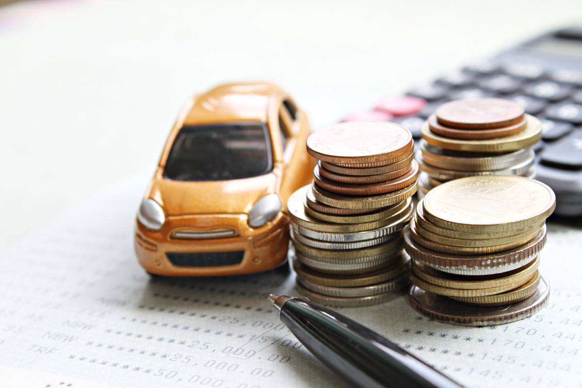 Licenciamento de carro: imagem com um carro miniatura e pilhas de moedas