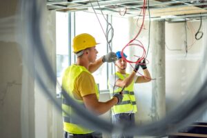 Homens fazendo instalação elétrica em prédio