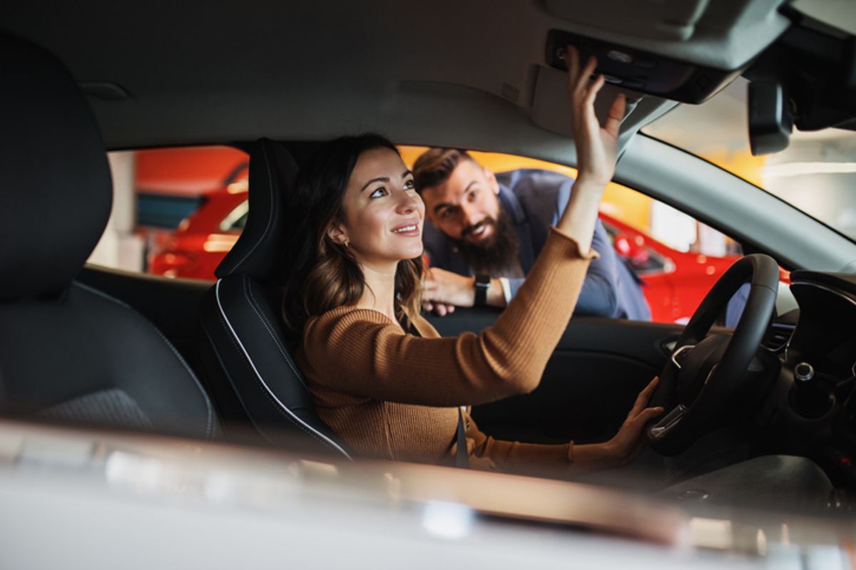 Dicas para vender seu carro - Na imagem um a mulher está conversando com um vendedor de dentro de um carro. 